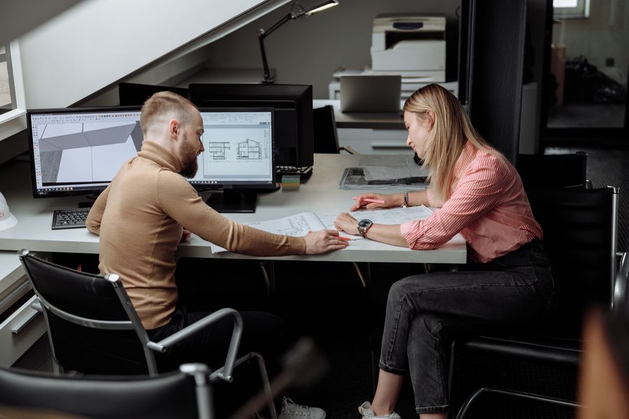 Two architects reviewing project plans together in a contemporary office