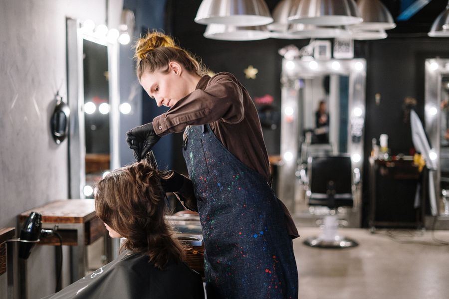 A stylist applying hair color to a client in a modern salon