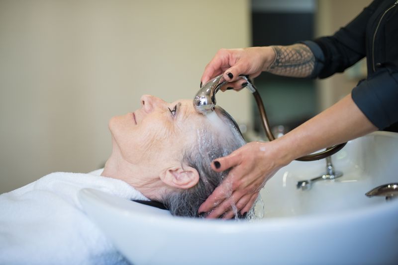 A client having their hair washed at the salon basin